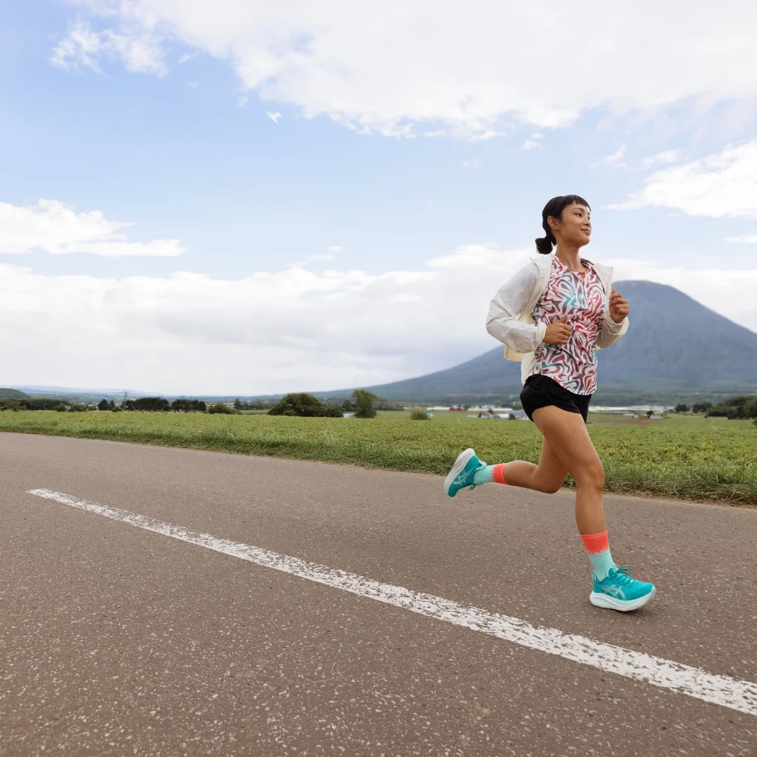 Women running on a road near mountains