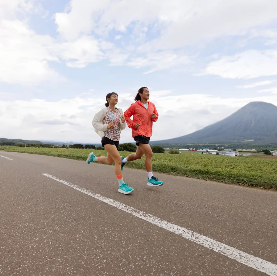A couple running on road near mountains