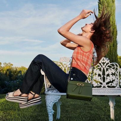Model on bench with handbag from Kate Spade New York