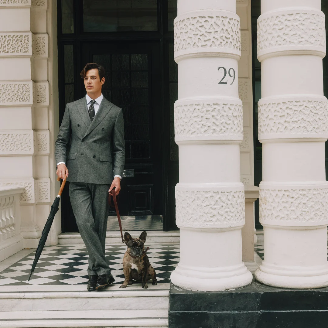 Man in Hawkes and Curtis Suit with a french bull dog and umbrella