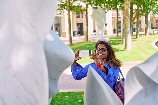 Woman taking a photo of a white sculpture