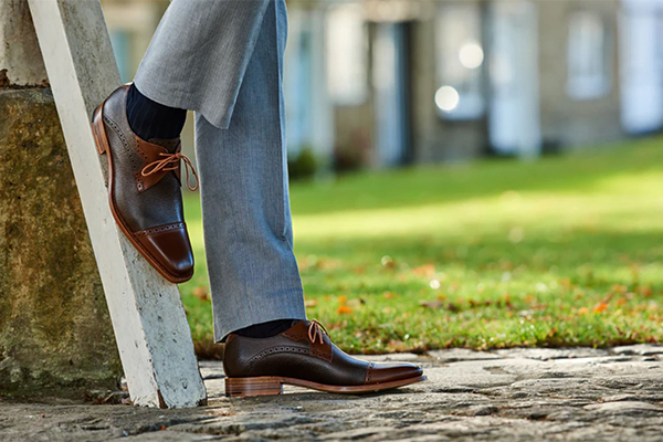 Man leaning against a tree wearing barker Shoes