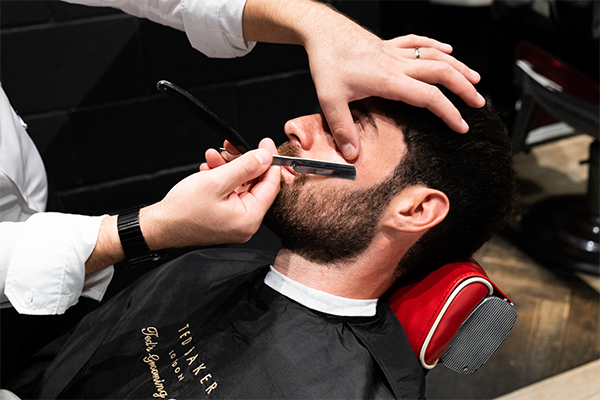 A man in a barber's chair being shaved 