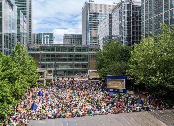 A crowd of people watching Wimbledon final on Summer screen at Canada square park