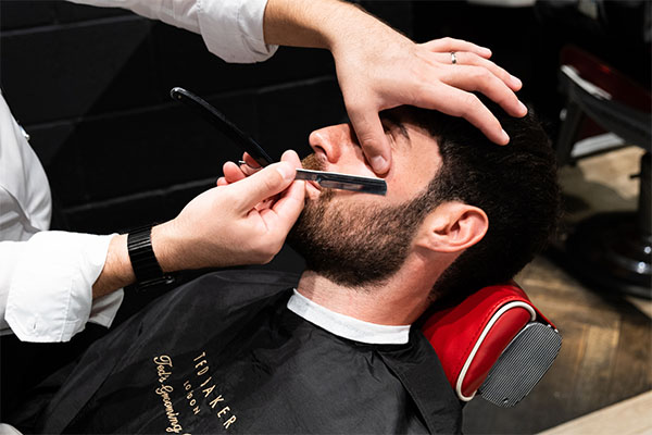 Man in barber's chair being shaved