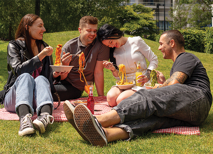 People eating pasta in the park
