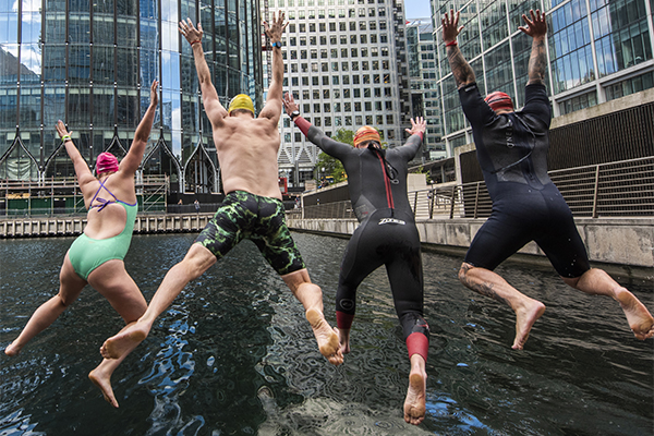 People jumping into the dock to swim at Canary Wharf