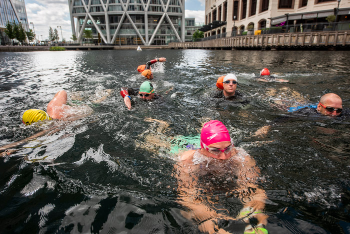 Swimmers splashing and enjoying open water in Canary Wharf