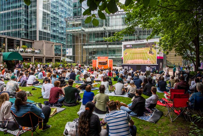 People enjoying watching games on the big screen outdoors