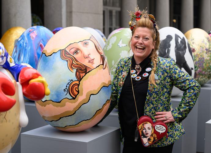 A lady taking picture with big egg sculpture in canary wharf