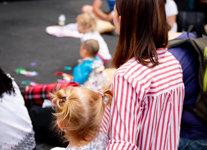 A mom and her child watching the performance