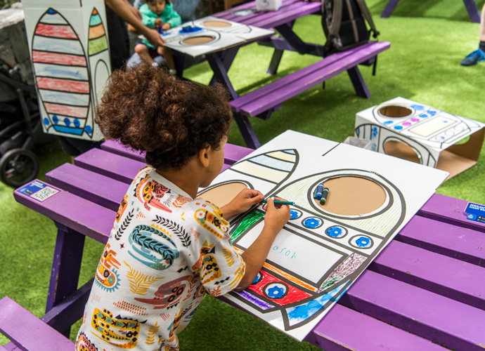 a child busy with colouring her artwork