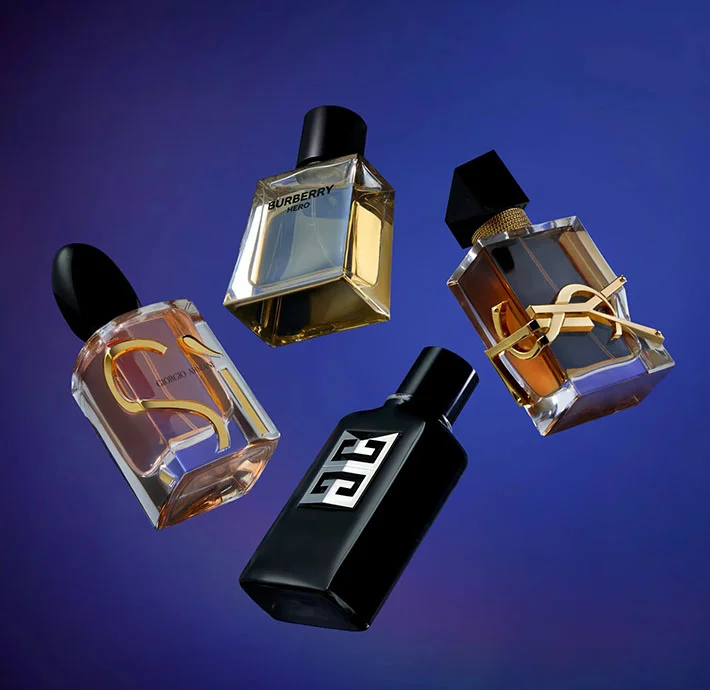 Perfumes falling on a blue backdrop