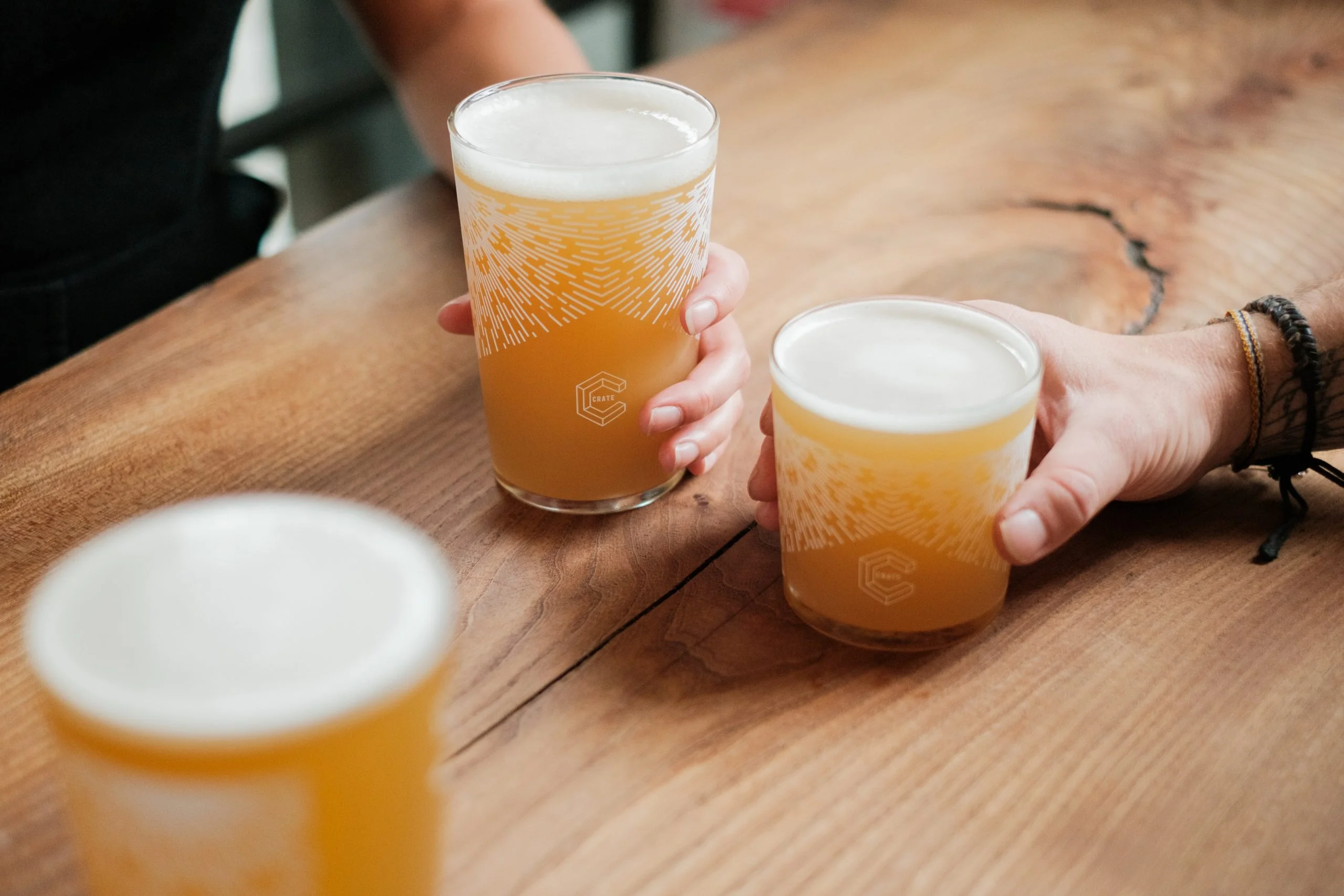 Hands holding pints of beer