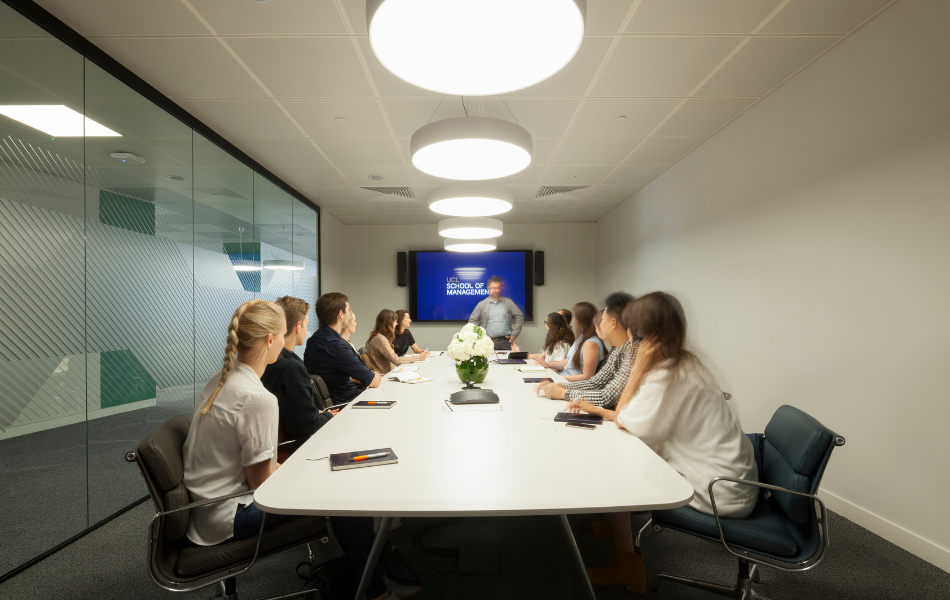 Meeting room with UCL School of Management on screen