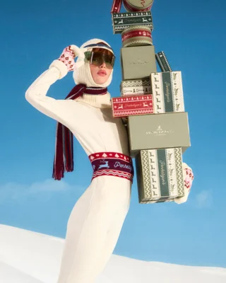 Women in ski outfit carrying boxes
