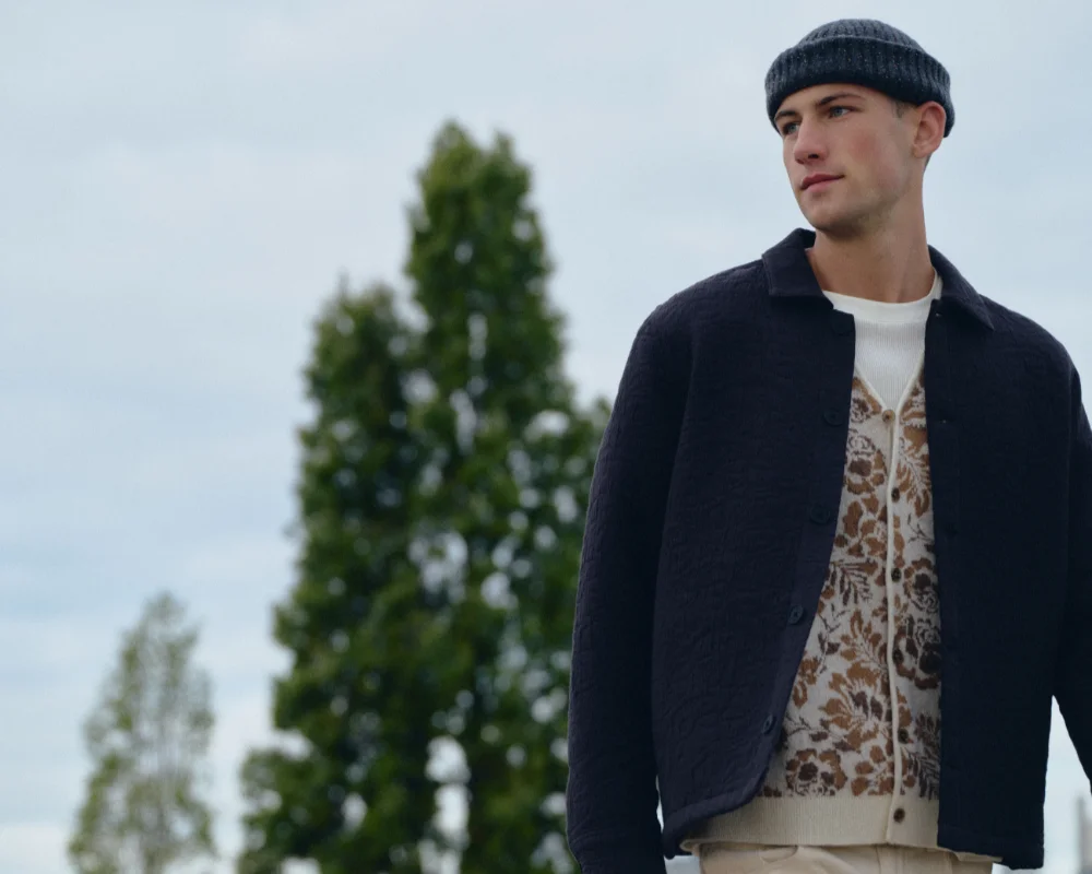 man in blue jacket, flower cardigan and hat