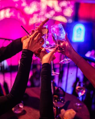 people holding their glasses up and cheering