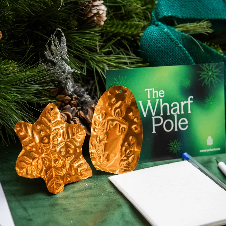 brass decorations on a green table with christmas tree behind